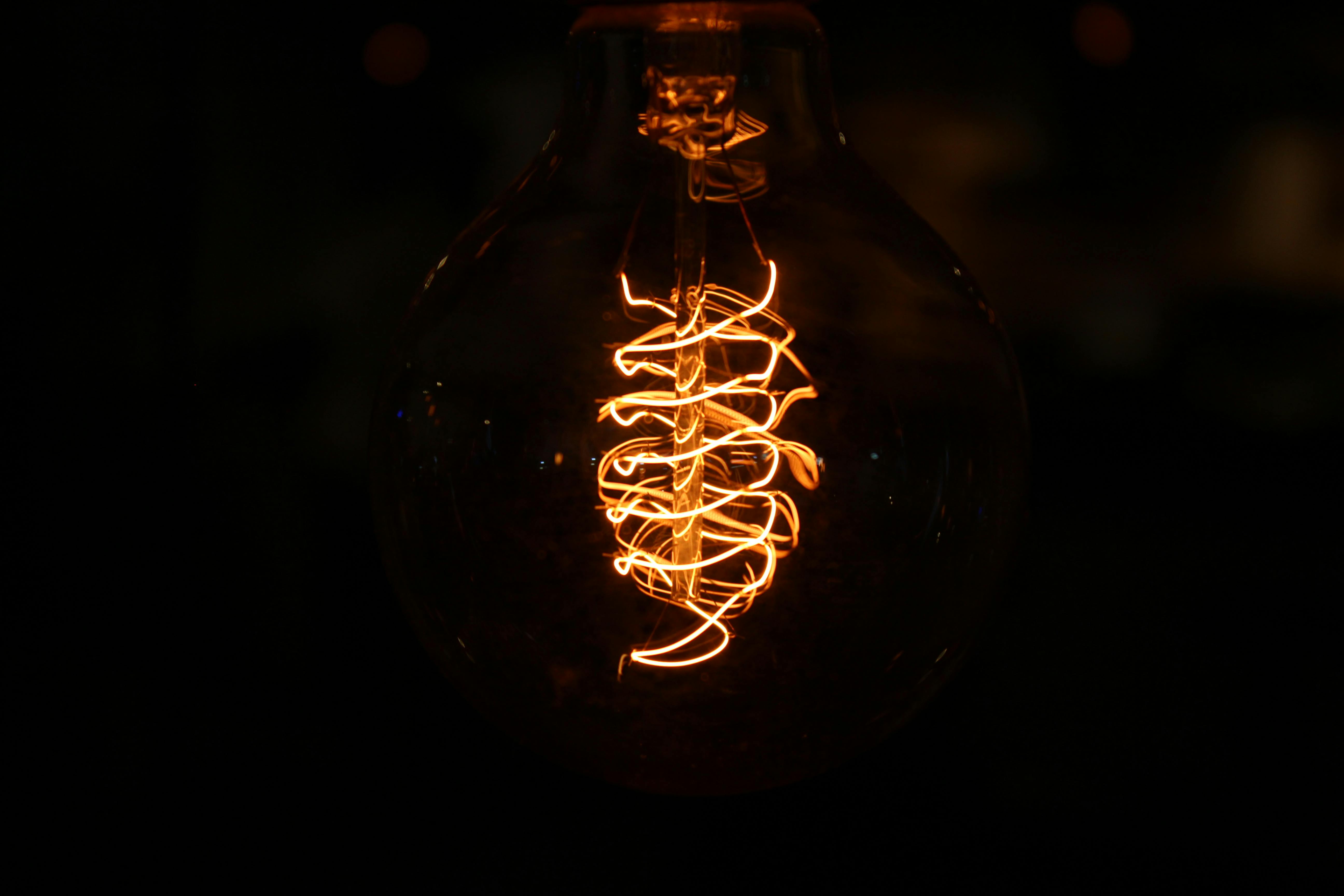 A mesmerizing view of a glowing filament inside an incandescent bulb against a dark background.